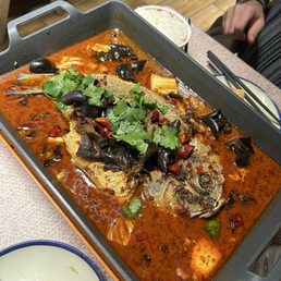 grilled fish entree served family style. we added wood ear mushrooms, but the broth comes with napa cabbage.