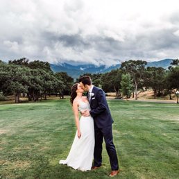 a bride and groom kissing in a field