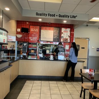 Flame Broiler - a woman standing in a restaurant - Korean Near Me - Tustin, California