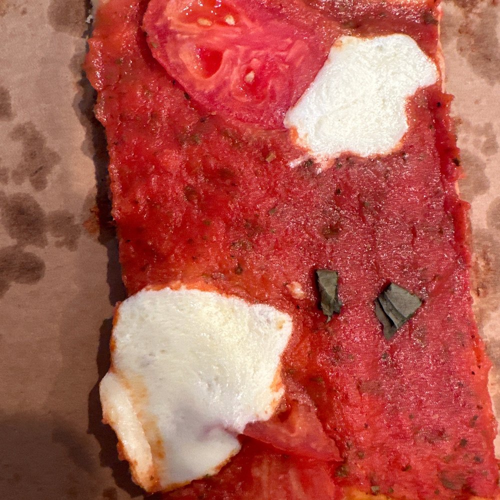 A slice of their Margharita pizza. A slice of their Margharita pizza.
