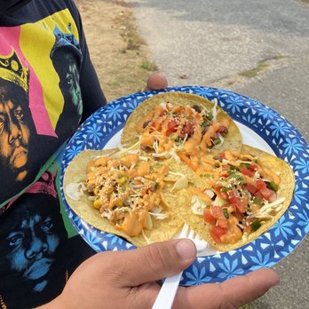 Tacos Del Seoul - a person holding a plate of food - Food Trucks Near Me