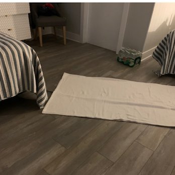 Coastal Inn - June 3, 2021 Extension cord covered by blanket.  This is the only way we would have AC as the majority of outlets did not work. - Hotels Near Me - Beulah, Michigan