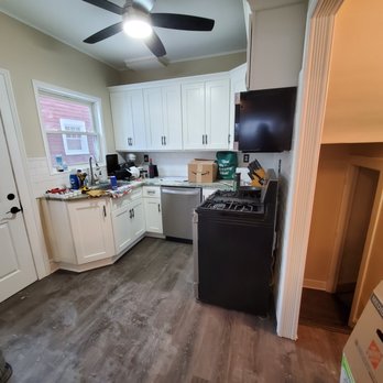 A&R Home Remodeling - a kitchen with white cabinets and black appliances - Flooring Near Me A&R Home Remodeling - a kitchen with white cabinets and black appliances - Flooring Near Me
