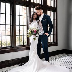 The Gilded Thistle - Couple at window of Venue3two holding spring wedding bouquet  Grand Rapids suburbs