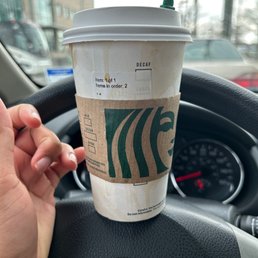a cup of coffee on a steering wheel a cup of coffee on a steering wheel