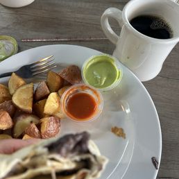 Breakfast burrito with eggs and ham and black refried beans. Potatoes. Hot coffee. Breakfast burrito with eggs and ham and black refried beans. Potatoes. Hot coffee.