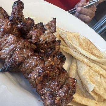 Karachi Kabobs - Delicious Beef Bihari Kabab! - A plate features grilled beef kebab, flatbread, and fried bread, served at a Pakistani cuisine eatery. - Pakistani Near Me - Algonquin, Illinois