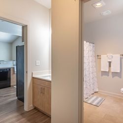 Forestplace Apartment Homes - A bathroom with a toilet, sink, and shower.