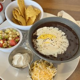 Black beans with egg, veggie salsa, cheese, sour cream, and chips