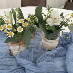 Small mason jars filled with flowers and eucalyptus Small mason jars filled with flowers and eucalyptus
