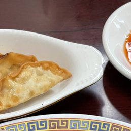 a plate of dumplings and dipping sauce