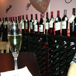 a woman sitting at a table with a glass of wine