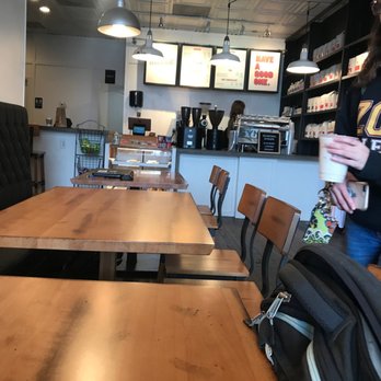 Muletown Coffee Roasters - a woman holding a cup of coffee - Coffee & Tea Near Me - Columbia, Tennessee