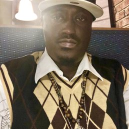 a man wearing a hat and sweater vest a man wearing a hat and sweater vest