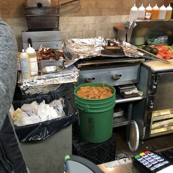 L Mo's Market - a man preparing food in a kitchen - Grocery Near Me - Brooklyn, New York