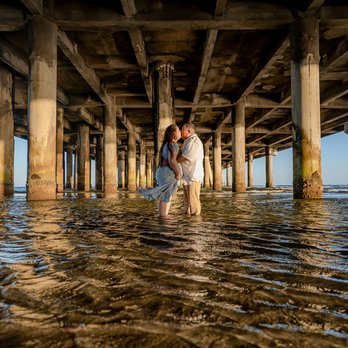 Adebiyi Studios - Golden hour beneath the pier--where love meets the sea. - Session Photography Near Me - Humble, Texas Adebiyi Studios - Golden hour beneath the pier--where love meets the sea. - Session Photography Near Me - Humble, Texas