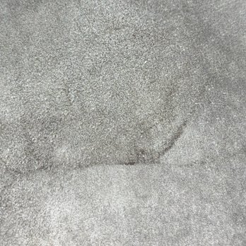 Tide Cleaners - A detailed view of a textured, sandy surface, likely concrete or similar material, with a faint, curved indentation or mark. The surface appears rough with small granules, and the indentation suggests a minor disturbance or impression in the material. - Dry Cleaning Near Me - Oswego, Illinois