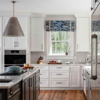 Bee Studios Design - a kitchen with white cabinets and wood floors - Interior Design Near Me - St. Petersburg, Florida