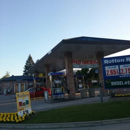 a gas station with a gas station sign in the foreground a gas station with a gas station sign in the foreground