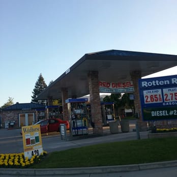 Rotten Robbie - a gas station with a gas station sign in the foreground - Gas Stations Near Me - Gilroy, California