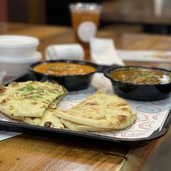 Twisted Indian Street Food - The naan-bread for the front of the picture the back left is butter, chicken, and the back right is lamb curry.