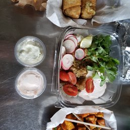 a meal in a plastic container with a variety of toppings a meal in a plastic container with a variety of toppings