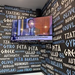Gyro Village - Steven A. Smith on one of many flat screen TVs.