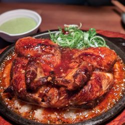 Nu-roong-ji Chicken Korean style rotisserie chicken over sizzling sticky rice, comes with green sauce and radish (Sweet and Spicy Style)
