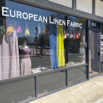 Zele Nava - Storefront from outside - The image shows the exterior of European Linen Fabric, featuring a large window display with various linen fabrics and a mannequin. The shop's name is visible at the top. - Fabric Stores Near Me - Waltham, Massachusetts