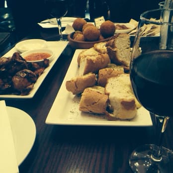 Wassail Wine Bar - Mustard cheesy bread, crushed potato to the left, arancini balls in the back. All with a nice glass of red. - Wine Bars Near Me - Prospect, SA