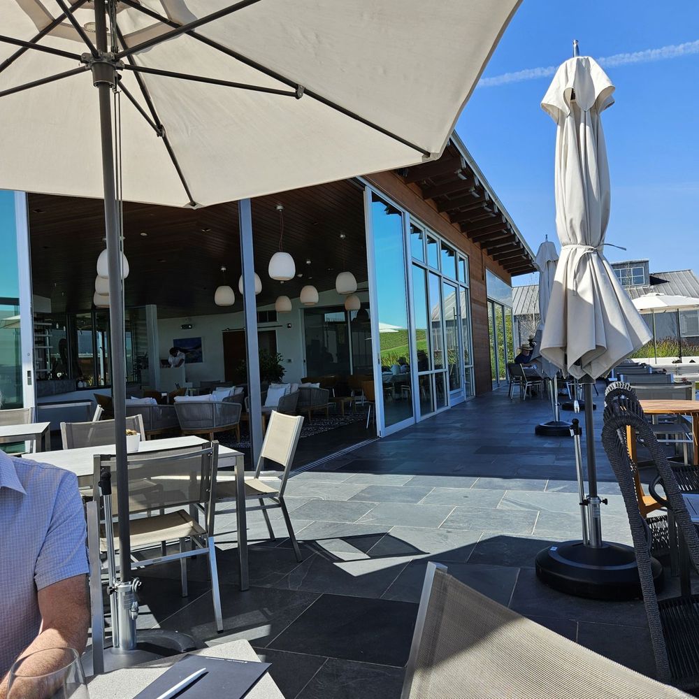 Cuvaison - Comfortable seating outdoors looking into the building - Wineries Near Me - Napa, California