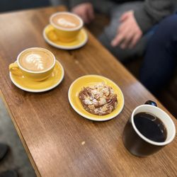 Flat white, mocha, black coffee, and almond bun