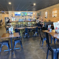 Large space with a bar, booths , and tables