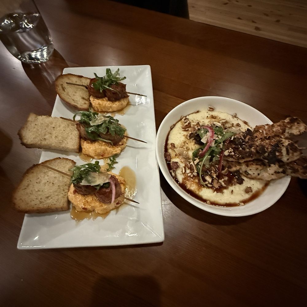 Oak & Olive - Bacon Wrapped Sausage with Pimento Cheese and Garlic Chicken and bourbon drizzled grits with pecans. - Wine Bars Near Me - Valdosta, Georgia Oak & Olive - Bacon Wrapped Sausage with Pimento Cheese and Garlic Chicken and bourbon drizzled grits with pecans. - Wine Bars Near Me - Valdosta, Georgia
