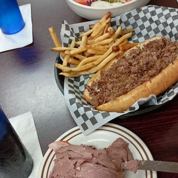 Dundee Diner - Lunch. - A cheeseburger with a beef patty, fries, a salad with vegetables, and sliced meats on a plate and in a bowl, served on a restaurant table. - New American Near Me - Dundee, Florida