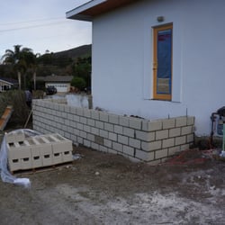 SLOmow - Retaining wall back door patio. Finish with concrete and stucco.