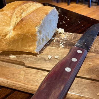 Ruby River - a loaf of bread on a cutting board with a knife - American Near Me - Ogden, Utah