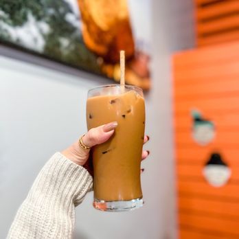New Burma - a hand holding a glass of iced coffee - Burmese Near Me - San Francisco, California