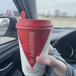 a hand holding a cup of coffee