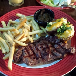 TGI Friday's - 8oz new york steak with fries and potato skins. Bourbon peppercorn sauce.