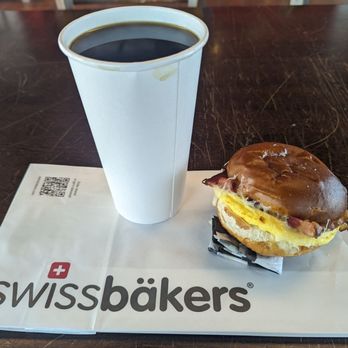 swissbakers - Large hot coffee & bacon, egg, cheese breakfast sandwich on pretzel bun - Bakeries Near Me - Allston, Massachusetts