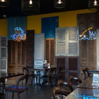 Saigonese Oc Lau & More - Interior wall of the restaurant with neon signs, decorative shutters, and tables. - Vietnamese Near Me - Orlando, Florida Saigonese Oc Lau & More - Interior wall of the restaurant with neon signs, decorative shutters, and tables. - Vietnamese Near Me - Orlando, Florida