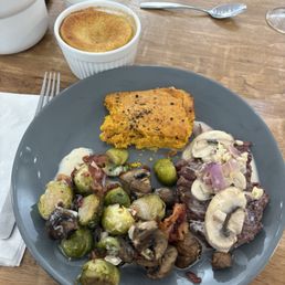 Steak with mushroom pan sauce, brussel sprouts with bacon, sweet potato soufflé, and grand marnier soufflé.