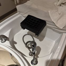 Yume Spa - Hard black plastic headrest without padding your head suspends over sink in throughout service