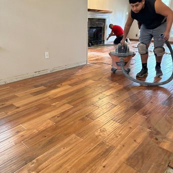 Superior Services - a man using a vacuum to clean a hardwood floor - Flooring Near Me Superior Services - a man using a vacuum to clean a hardwood floor - Flooring Near Me