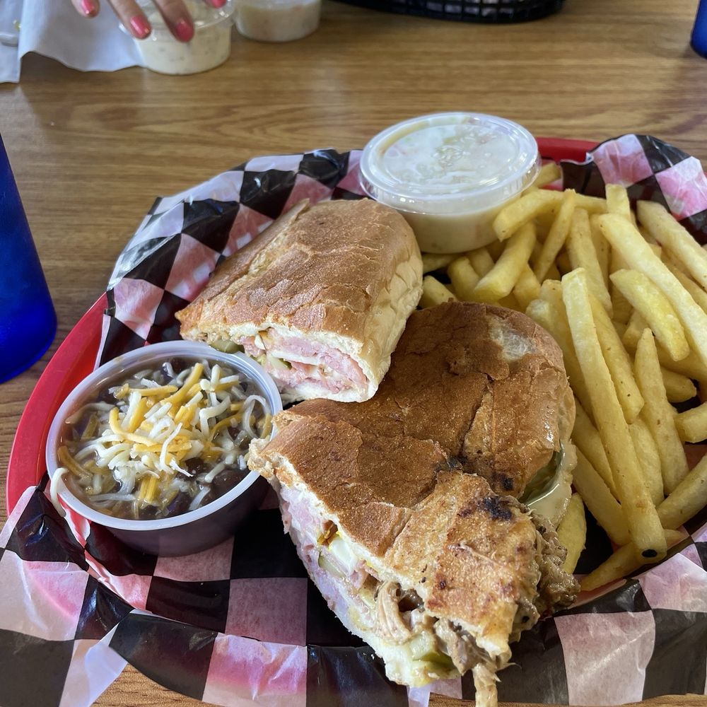 This is a Cuban sandwich with a side of beans and fries This is a Cuban sandwich with a side of beans and fries