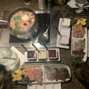 Photo of The Melting Pot - Jenks, OK, United States. In the pot is burgundy wine, scallions, mushrooms and garlic.