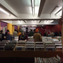 Vinyl Tap - Basement with large selection of used vinyl - live band on stage in background.
