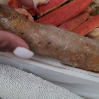 Louisiana Seafood - a person holding a sausage and a sandwich - Seafood Markets Near Me - Atlanta, Georgia Louisiana Seafood - a person holding a sausage and a sandwich - Seafood Markets Near Me - Atlanta, Georgia