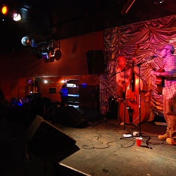 Que Sera - a man standing on a stage with a microphone - Dive Bars Near Me - Long Beach, California Que Sera - a man standing on a stage with a microphone - Dive Bars Near Me - Long Beach, California